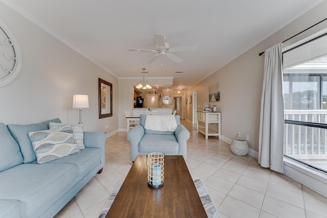 living room with light tile patterned floors, ceiling fan with notable chandelier, and ornamental molding