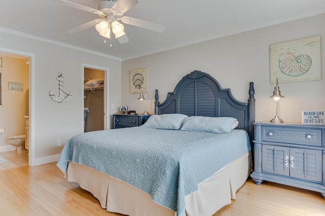 bedroom featuring a walk in closet, light hardwood / wood-style flooring, ceiling fan, connected bathroom, and a closet