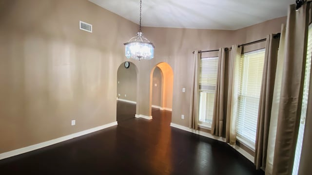 unfurnished dining area with dark hardwood / wood-style floors and an inviting chandelier