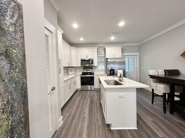 kitchen featuring stainless steel appliances, an island with sink, sink, and white cabinets