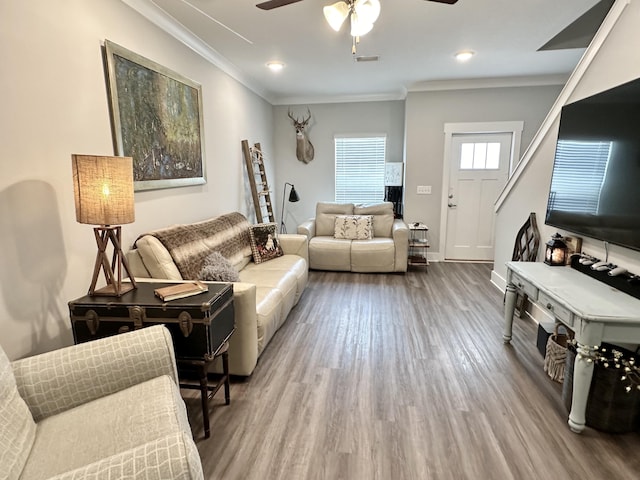 living room featuring hardwood / wood-style flooring, ceiling fan, and ornamental molding