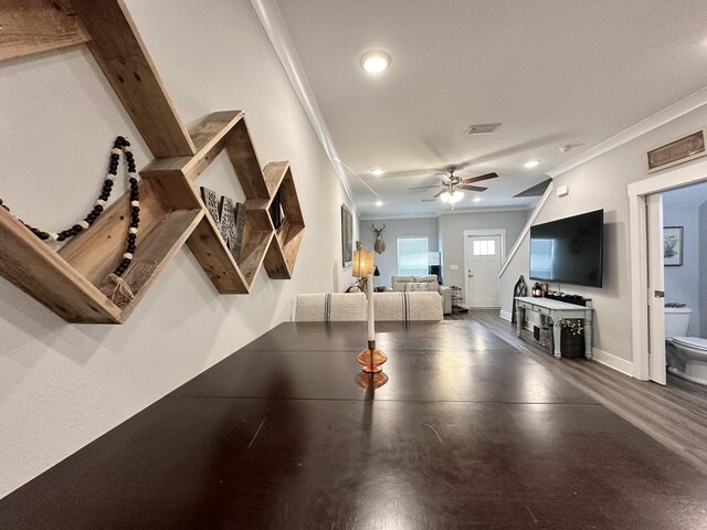 rec room featuring ceiling fan, dark wood-type flooring, and ornamental molding