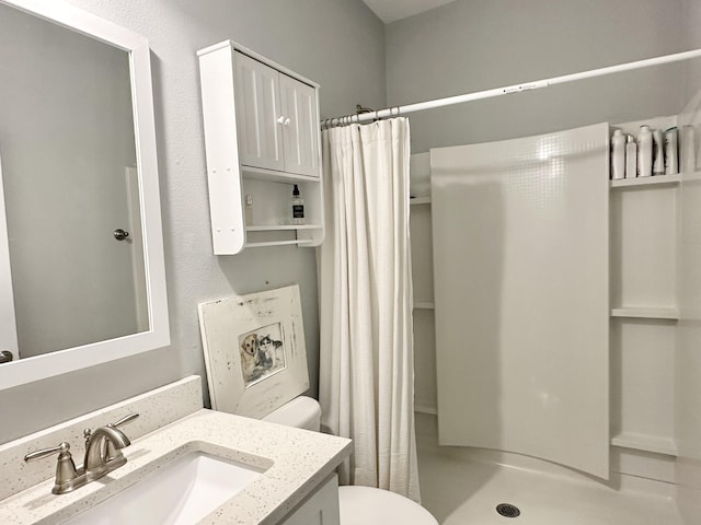 bathroom featuring curtained shower, vanity, and toilet