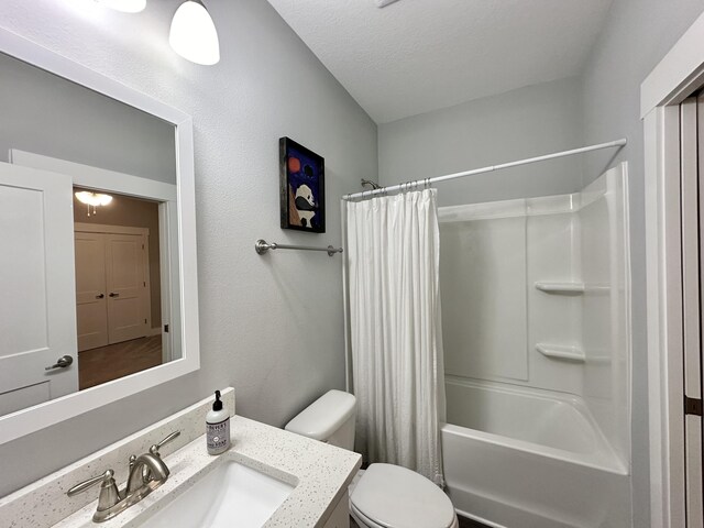 full bathroom featuring vanity, a textured ceiling, toilet, and shower / bath combo with shower curtain