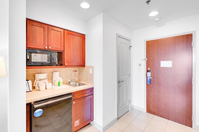 kitchen featuring tasteful backsplash, sink, light tile patterned floors, and black appliances