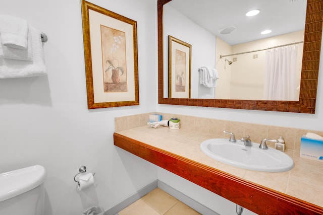 bathroom featuring tile patterned flooring, a shower with curtain, toilet, and sink