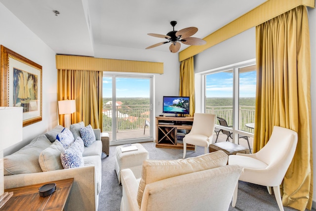 living room featuring a wealth of natural light, ceiling fan, and carpet