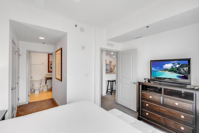 carpeted bedroom featuring ensuite bath