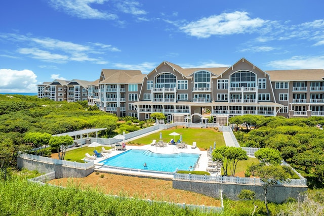 pool with a pergola, a patio, and fence