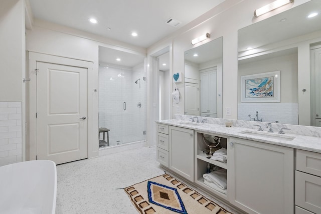 bathroom featuring double vanity, recessed lighting, a stall shower, and a sink