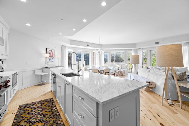 37 S Compass Point Way Unit 107, Inlet Beach, FL 32461 - kitchen with light wood finished floors, an island with sink, open floor plan, light stone countertops, and recessed lighting