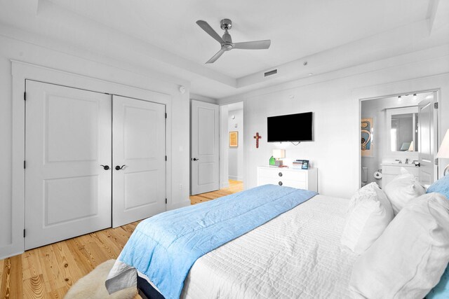 bedroom featuring a closet, visible vents, light wood finished floors, and ceiling fan