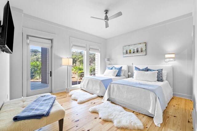 bedroom featuring ceiling fan, multiple windows, wood finished floors, and access to outside