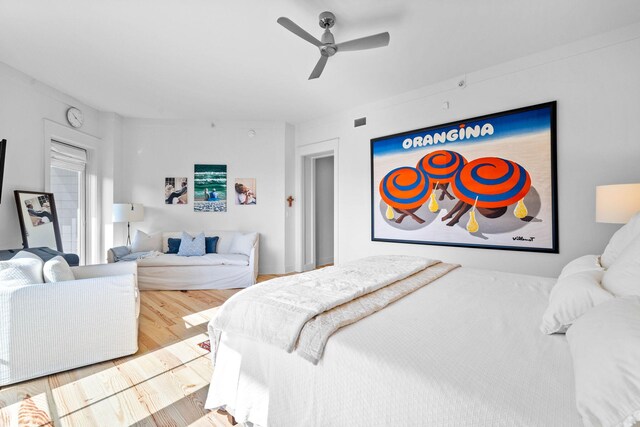 bedroom with ceiling fan, visible vents, and wood finished floors