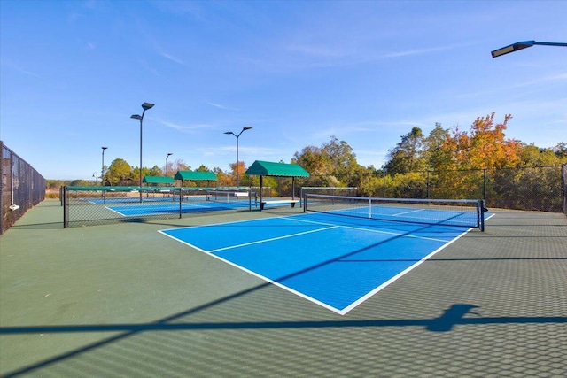 view of tennis court featuring basketball hoop