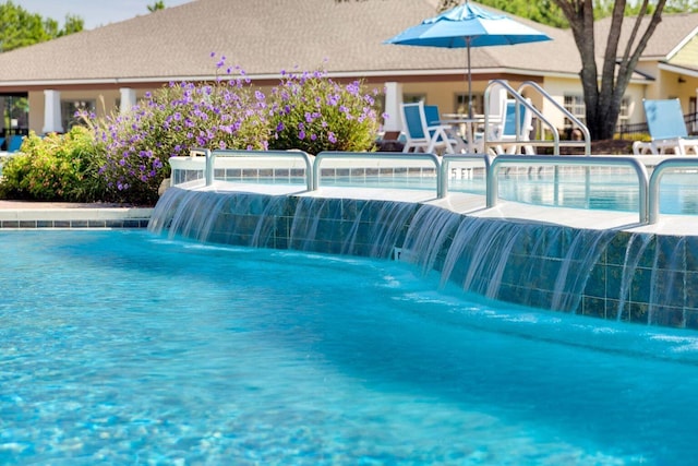 view of swimming pool with pool water feature