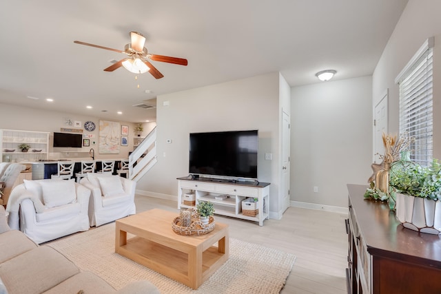 living room featuring ceiling fan and light hardwood / wood-style flooring