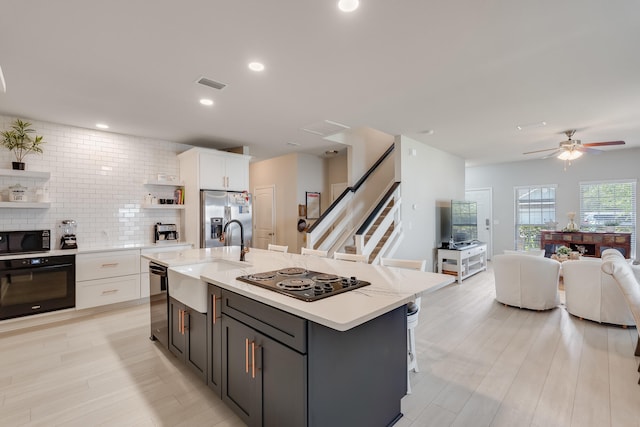 168 Secret St, Freeport, FL 32439 - kitchen featuring a sink, black appliances, white cabinetry, open floor plan, and open shelves