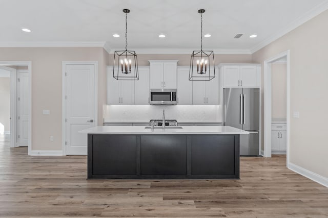 kitchen with stainless steel appliances, white cabinetry, a center island with sink, and light hardwood / wood-style flooring