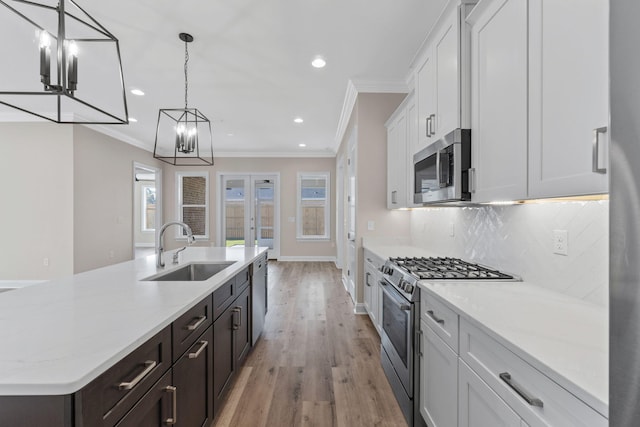 kitchen featuring pendant lighting, white cabinetry, sink, and appliances with stainless steel finishes