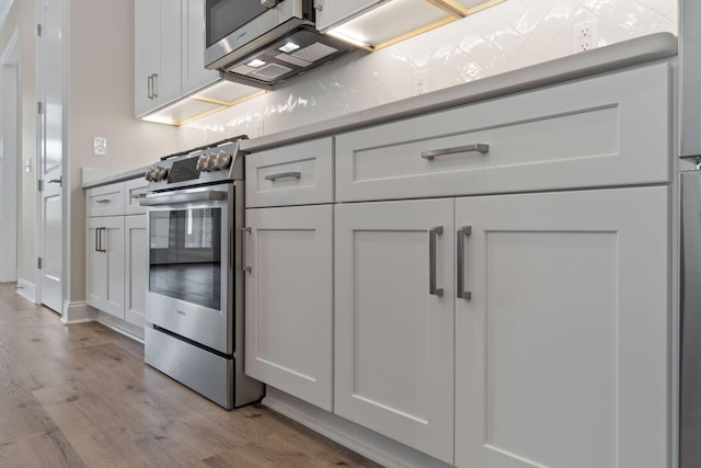 kitchen with white cabinets, electric range, and light hardwood / wood-style flooring