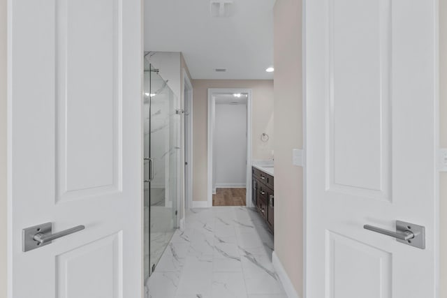 bathroom with vanity and a shower with shower door