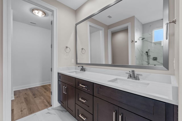 bathroom with vanity and tiled shower