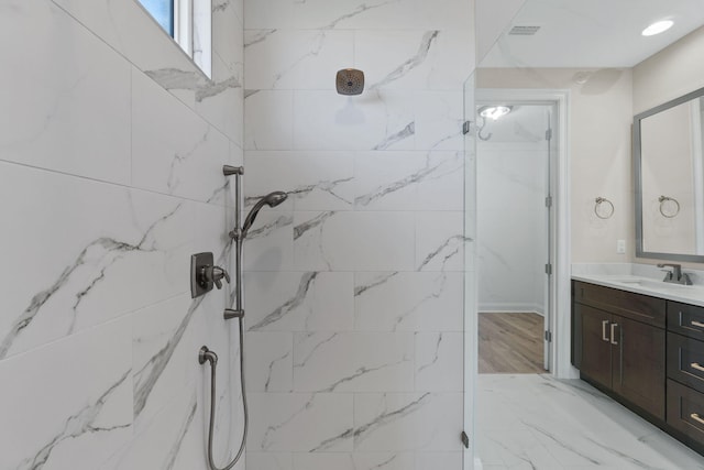 bathroom with vanity and a tile shower