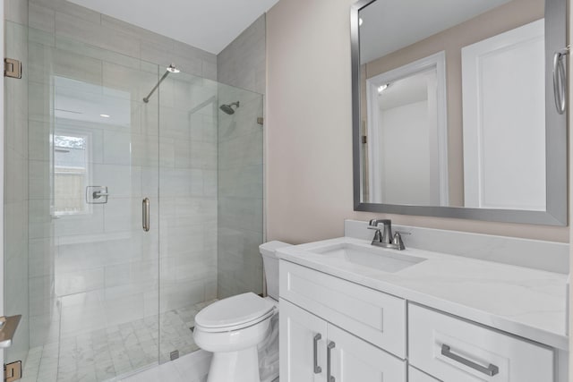 bathroom featuring vanity, toilet, and a shower with shower door