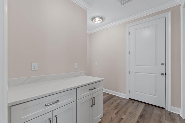 bathroom featuring hardwood / wood-style floors, vanity, and ornamental molding