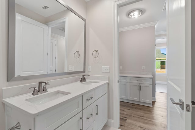 bathroom with vanity, hardwood / wood-style flooring, and ornamental molding