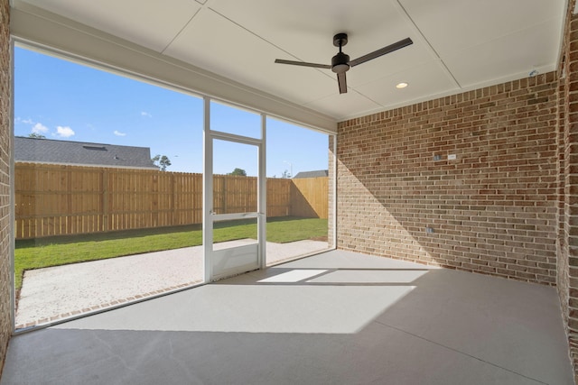 unfurnished sunroom with ceiling fan