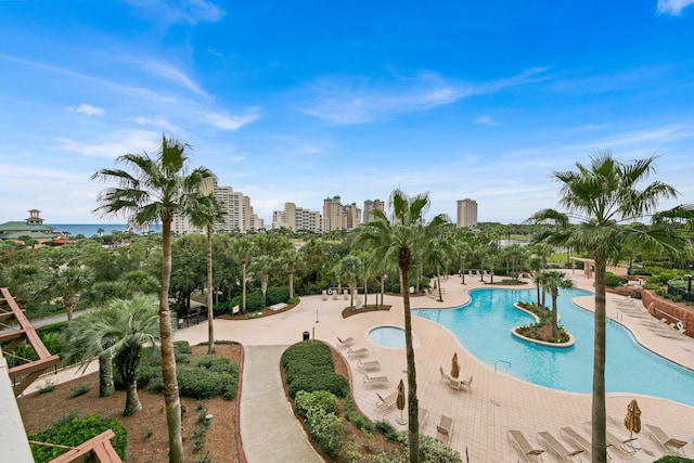 view of pool featuring a jacuzzi, a patio area, and a water view