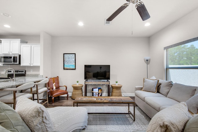 living room with wood-type flooring and ceiling fan