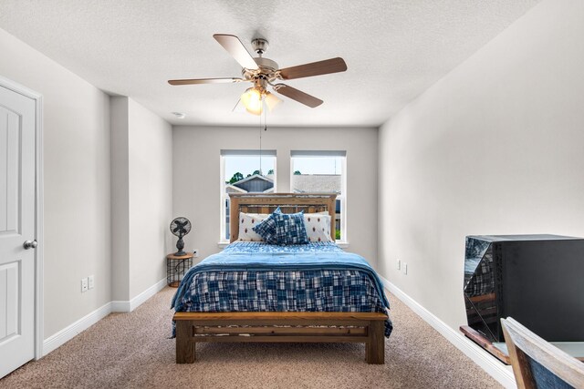 bedroom featuring ceiling fan, a textured ceiling, and carpet flooring