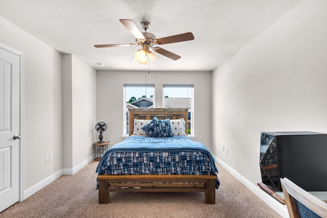 carpeted bedroom with ceiling fan and a textured ceiling