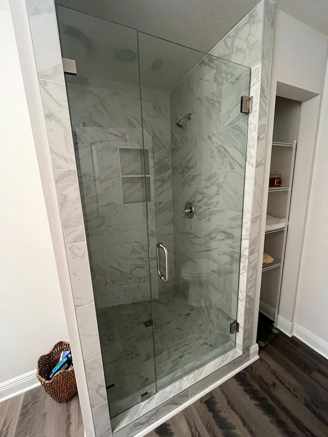 bathroom featuring hardwood / wood-style floors and a shower with shower door