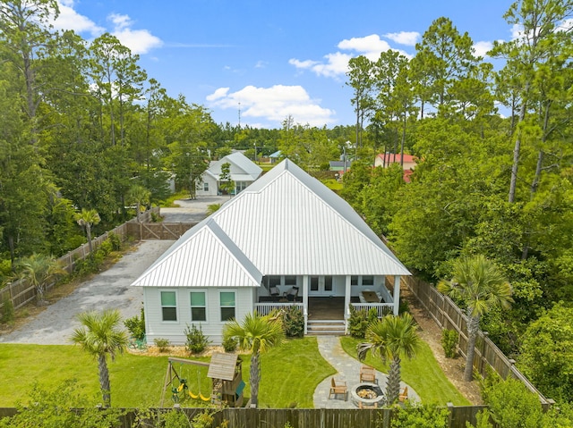 rear view of property with covered porch and a lawn