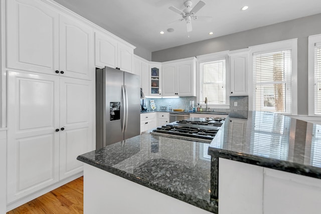 kitchen featuring appliances with stainless steel finishes, backsplash, white cabinetry, and ceiling fan