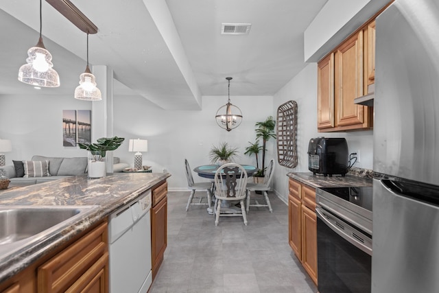 kitchen with stainless steel fridge, white dishwasher, decorative light fixtures, and range