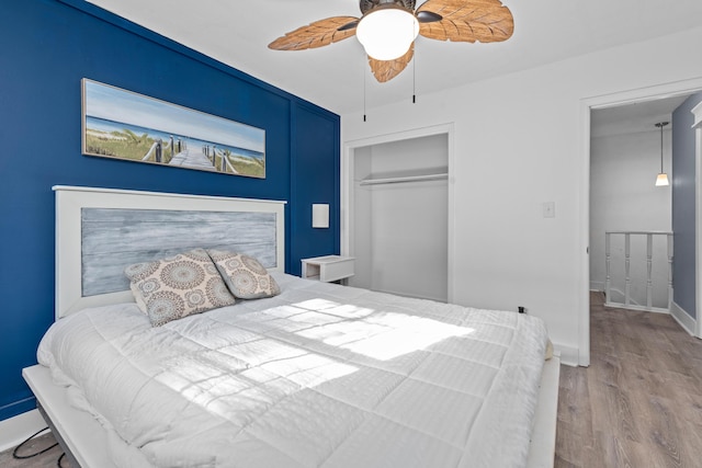 bedroom featuring ceiling fan, a closet, and light wood-type flooring