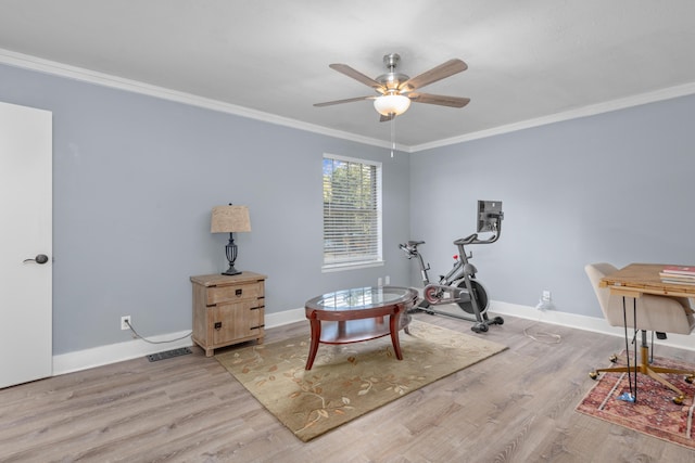 workout room featuring ceiling fan, light wood-type flooring, and ornamental molding