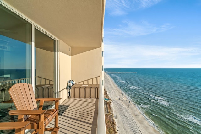 balcony featuring a beach view and a water view