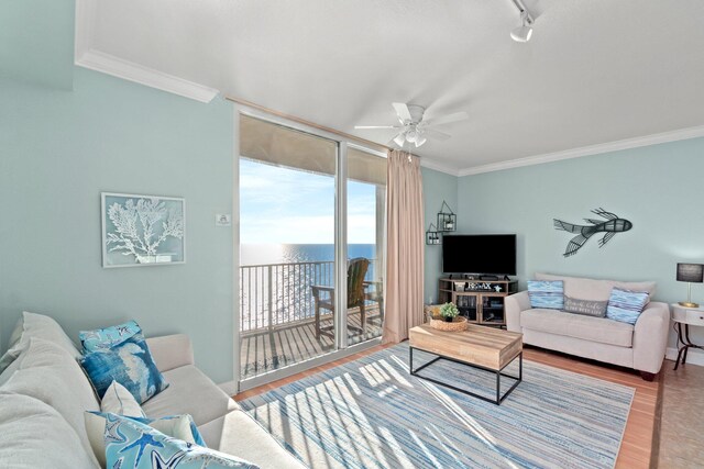 living room with ornamental molding, wood-type flooring, ceiling fan, and a water view