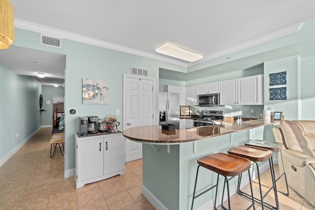 kitchen with stainless steel appliances, crown molding, white cabinetry, and light tile floors