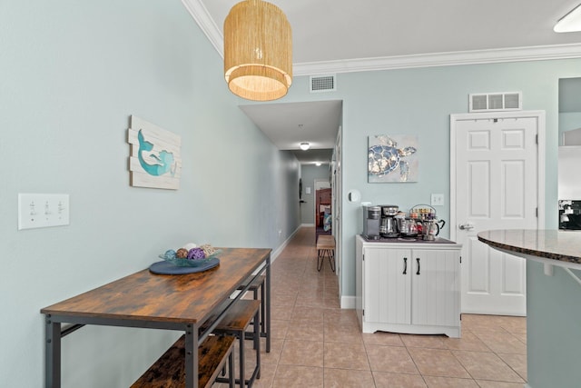 dining room featuring ornamental molding and light tile floors