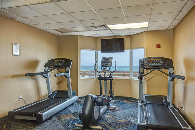 exercise room featuring a water view and a drop ceiling