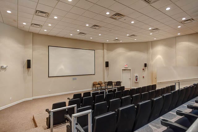 carpeted home theater featuring a drop ceiling