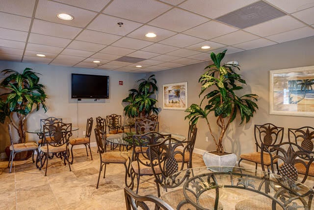 dining space featuring a paneled ceiling and light tile floors