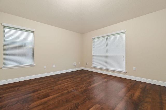 empty room with dark hardwood / wood-style flooring